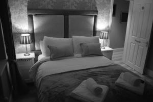 索尔兹伯里灰狗威尔顿宾馆的一间卧室配有一张大床和毛巾