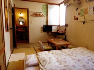 函馆梦空馆膳宿公寓酒店的一间卧室配有一张床、一张桌子和一个窗户。