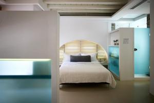米克诺斯城Semeli Hotel Mykonos的一间卧室配有一张带木制床头板的床