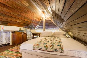 吉隆坡吉隆坡城市中心经典马来屋旅馆的一张位于带木制天花板的客房内的大床