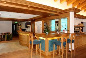 采尔马特高山天堂酒店的一间大厨房,内设一间酒吧,配有蓝色座椅