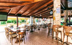 玛利亚Yiannis Manos Hotel Resort的一间带桌椅的餐厅和一间酒吧