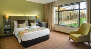 内罗毕罗望子树酒店的卧室配有床、椅子和窗户。