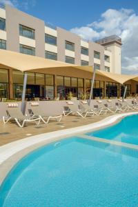 内罗毕罗望子树酒店的一座带游泳池和椅子的酒店和一座建筑