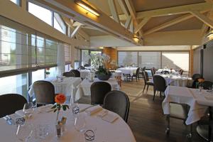 维桑堡磨坊德拉城酒店的用餐室配有桌椅和白色的桌布