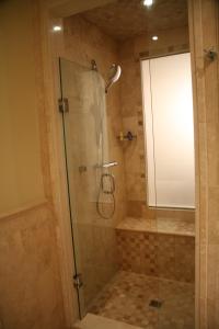 格雷斯湾中庭度假酒店的浴室里设有玻璃门淋浴