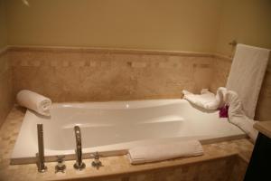 格雷斯湾中庭度假酒店的浴室配有浴缸和毛巾。