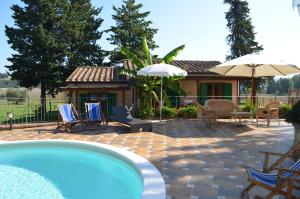 波马兰切Agriturismo Rosa dei Venti的房屋旁的游泳池配有椅子和遮阳伞
