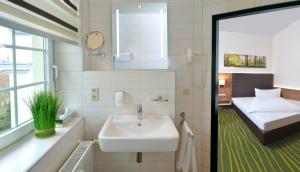 格劳豪迈耶酒店的一间带水槽的浴室和一张位于客房内的床