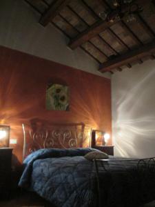乌尔比诺伊尔蒙克多住宿加早餐旅馆的卧室配有一张床,墙上有两盏灯