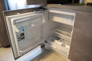 米兰Warrest - Short Rent Apartments的厨房里空着冰箱,门开