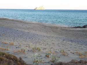 赛罗卡波斯Akti Rooms的沙滩上,水里有岩石