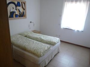 滕诺Appartamento Mora的一间卧室设有两张床和窗户。