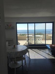 勒格罗-迪鲁瓦Exceptionnel, sur la plage en front de mer的客厅配有桌子,享有海景