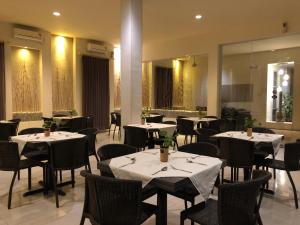 Sedati仙娜1号酒店的餐厅设有桌椅和镜子