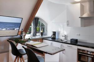 Sint MaartensbrugVilla Mare的厨房配有桌椅和电视。