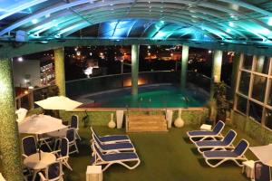 恩卡纳西翁卢克撒酒店的一个带桌椅的室内庭院和一个游泳池