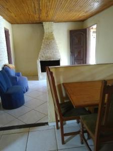 圣托梅-达斯莱特拉斯Sitio Vale das Montanhas的客厅设有壁炉、桌子和椅子
