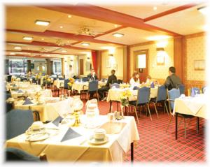 拉格斯柳堤酒店的一间设有白色桌子的餐厅,有坐在桌子上的人