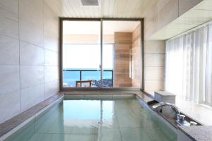 鸭川市鸭川潮骚度假酒店的一间带大窗户的游泳池的浴室