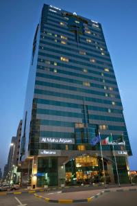 阿布扎比马哈阿江罗塔纳酒店公寓的一座高大的建筑,旁边有一个标志