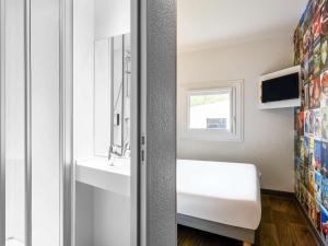 朗吉斯伦吉斯奥利一级方程式酒店的一间带水槽和卫生间的浴室以及窗户。