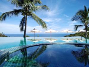 涛岛Tanote Villa SHA Extra Plus的一个带遮阳伞和海洋的游泳池