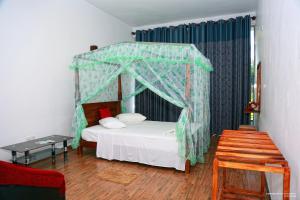 蒂瑟默哈拉默湖边假日旅馆的一间卧室配有一张天蓬床和一张桌子