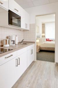 柏林波林公寓的一间带白色橱柜的厨房和一间客厅