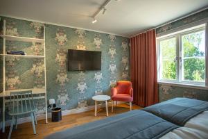林德斯贝里Lindesbergs Hotell的卧室配有一张床,墙上配有电视。