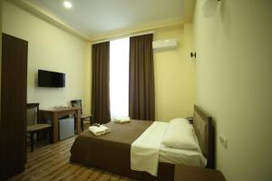 库塔伊西Hotel Comfort的配有一张床、一张书桌和一扇窗户的酒店客房