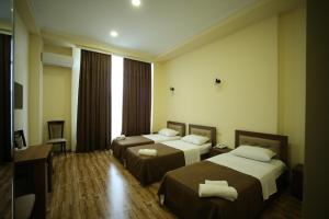 库塔伊西Hotel Comfort的酒店客房设有两张床和电视。