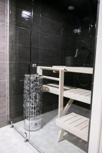 罗瓦涅米Santasport Apartment Hotel的带淋浴和淋浴旁长凳的浴室