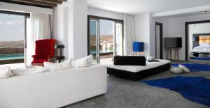 埃利亚海滩Myconian Avaton, a Member of Design Hotels的客厅配有2张白色沙发和1把红色椅子