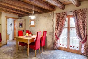 NembiaChalet Sogno di Fiaba的一间带木桌和红色椅子的用餐室