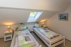 梅特拉赫Ferienwohnung Saarschleife的阁楼卧室设有两张床和窗户。