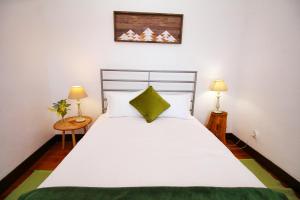 蓬塔杜帕戈Casa Benedita的卧室配有一张白色大床和两盏灯。