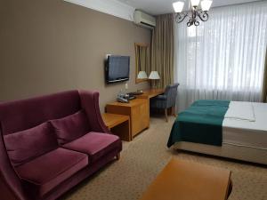 阿斯塔纳Prestige的酒店客房,配有床和沙发