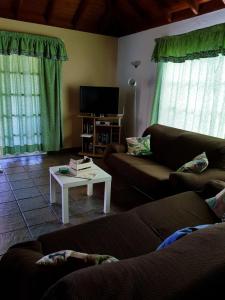 洛斯·亚诺斯·德·阿里丹Casa Óscar的客厅配有两张沙发和一台电视机