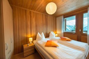 阿罗萨Casa Serena的一间卧室配有带白色床单和橙色枕头的床。