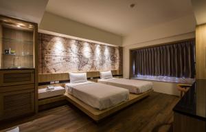 台南永华春休闲商务旅馆的酒店客房设有两张床和窗户。