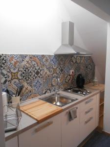 比萨CIVICO 47的厨房设有水槽和瓷砖墙