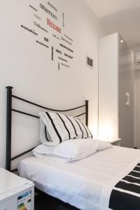 罗马Eden guest house的卧室配有一张墙上写着字条的床