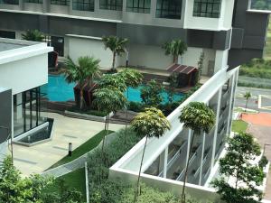 普特拉贾亚i-Walker @ IOI Conezion Putrajaya的享有带游泳池和棕榈树的建筑的空中景致