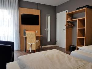 Barweiler霍勒餐厅&酒店的一间卧室配有一张床、一张书桌和一台电视