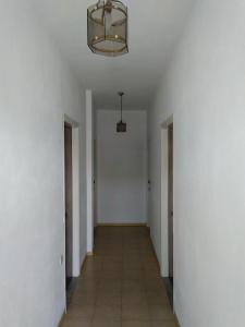 科孚镇SAM΄S ROOMS的走廊设有白色墙壁和带吊灯的天花板