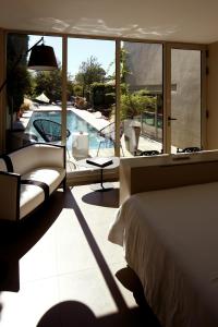 圣阿姆贝尔维尤天堂客栈的一间卧室配有一张床,享有游泳池的景色