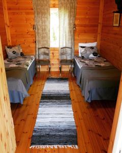 拉彭兰塔Guesthouse Miekkala的铺有木地板的客房内的两张床