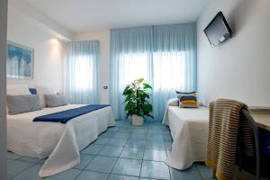 马奥莱安吉丽娜住宅公寓的一间卧室设有两张床和盆栽植物