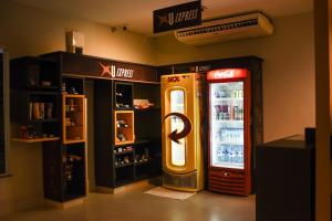 博阿维斯塔Uiramutam Palace Hotel的饮料冷却器旁边的古柯可乐机